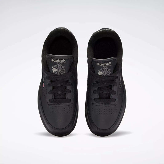 Top view of Kids' Club C Shoes by Reebok: classic black sneakers featuring a durable leather upper, black laces, perforated toe details, and Reebok logos on each tongue.
