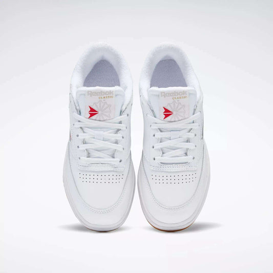 A pair of white Reebok Women's Club C Double Shoes with white laces, seen from above, featuring perforated toe details, a platform midsole, and Reebok branding on the tongue.