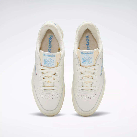 A pair of Club C 85 Vintage Shoes by Reebok, seen from above, with an off-white leather upper, light blue Reebok branding on the tongue and side, cream laces, and a soft textured inner lining.