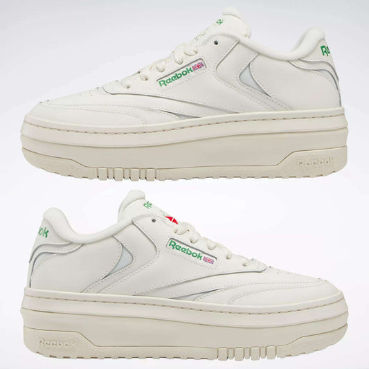 Two white Reebok Women's Club C Extra Shoes with thick platform midsoles, green and red logos, and grey accents are shown side by side against a plain light background.