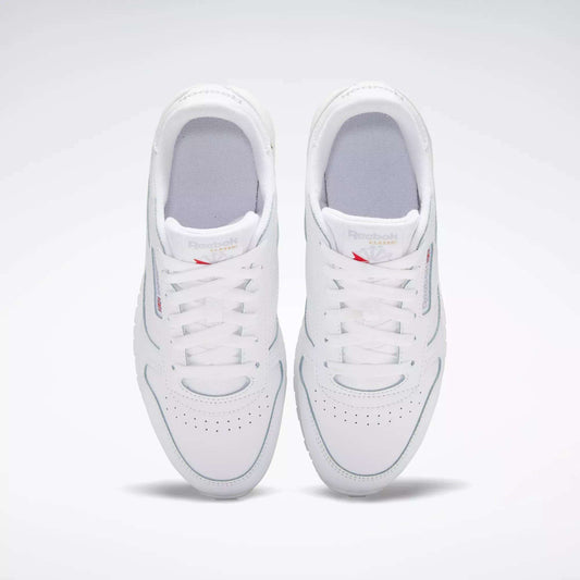 A pair of Reebok Classic Leather Shoes for big kids in white, viewed from above with both shoes side by side, laces tied, and subtle branding on the tongues—a timeless design.