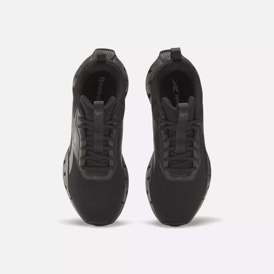 A pair of Reebok Zig Dynamica STR Shoes in black is shown from above, highlighting the laces, tongue, and branded insoles on a plain light background—progressive running shoes combining comfort and style for daily wear.
