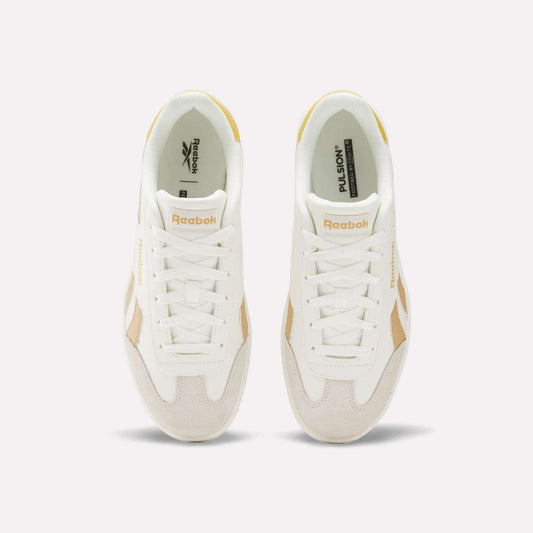 Top view of Reebok Smash Edge Shoes in white with beige details, displaying the Reebok logo on tongue and side, set against a plain light background. Ideal for those seeking stylish and comfortable indoor soccer footwear.