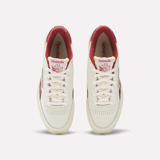 A pair of Reebok Club C Revenge Vintage Shoes are shown from above on a light background. These white sneakers feature red interiors and logos, subtle toe perforations, classic white laces, and full-grain leather uppers.