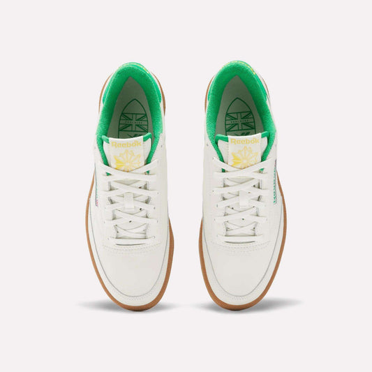 The Reebok Men's Club C Golf Shoes feature a white, water-resistant leather upper, green inner lining, white laces, gum soles, spikeless outsole, and yellow-green tongue branding—shown from above on a plain background.