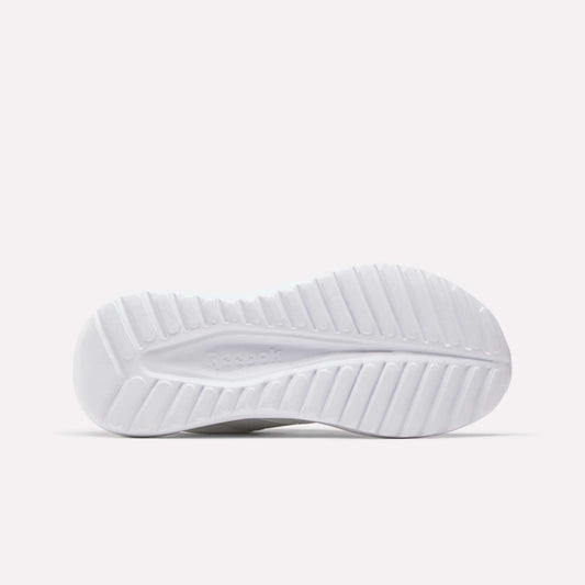 The white sole of the Reebok Women's Energen Lux Running Shoes, designed with a ridged, textured tread for grip and flexibility, is photographed against a plain light background.
