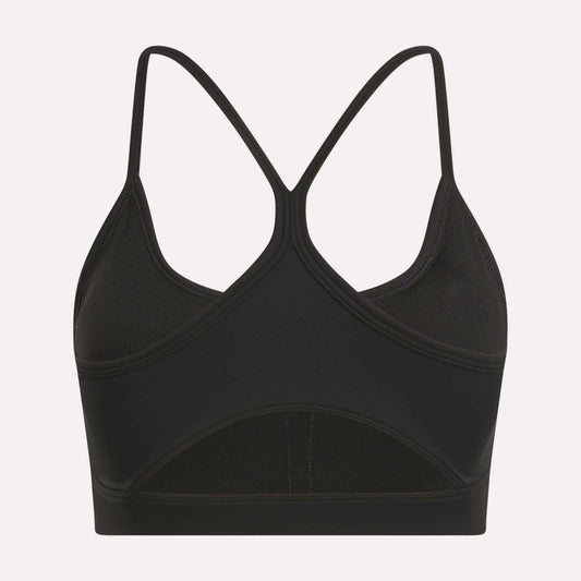 The Reebok Women's Core Strappy Bra offers medium support with thin, crisscrossed racerback straps and a seamless black design—ideal for workouts. Displayed on a plain white background.
