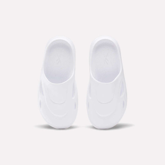 The Reebok DMX Recovery Mules are white slip-on shoes featuring a futuristic design with oval side cutouts, crafted from molded EVA, shown from above on a plain light background.