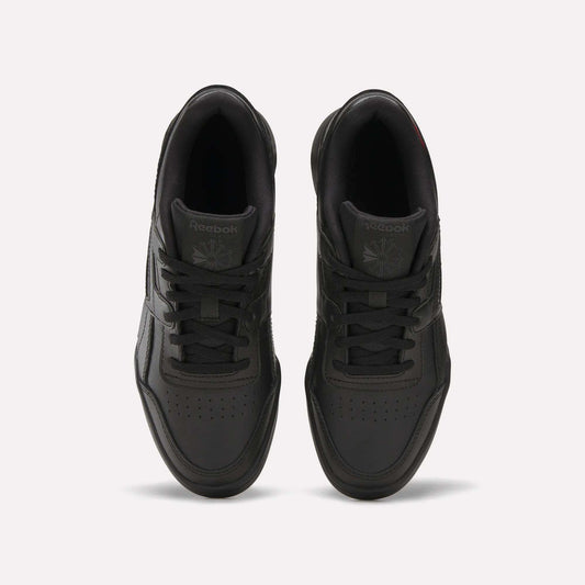 Top view of a pair of black Reebok Workout Plus Shoes for big kids with laces, displayed side by side on a white background. The Reebok logo appears on the tongue of each sneaker.