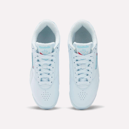 A top-down view of Reebok Women's Freestyle Lo Shoes—white leather sneakers with laces, light blue accents, and the Reebok logo on the tongue and side—designed for everyday wear.