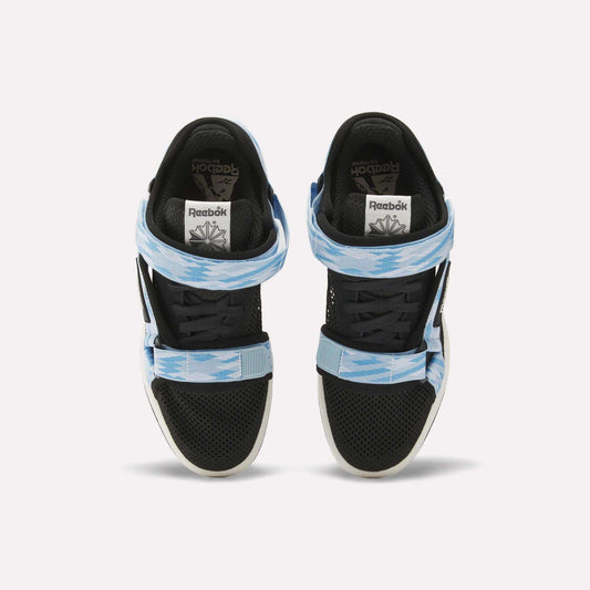 Two black Reebok x MARKET Club C 85 Shoes are shown from above, featuring tennis-inspired details, two patterned light blue and white Velcro straps across the front, and a white Reebok logo on the tongue.