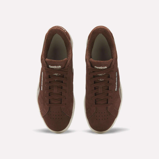 A pair of Reebok Club C Grounds UK Shoes in brown suede viewed from above, with white soles, laces, and Reebok branding on the tongue and side, delivering a classic vintage tennis style.