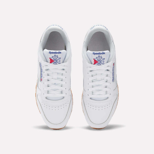 A pair of Reebok Classic Leather Shoes in white, seen from above, with white laces, a gum sole, and the iconic blue and red logo—these retro Reebok sneakers deliver timeless style.