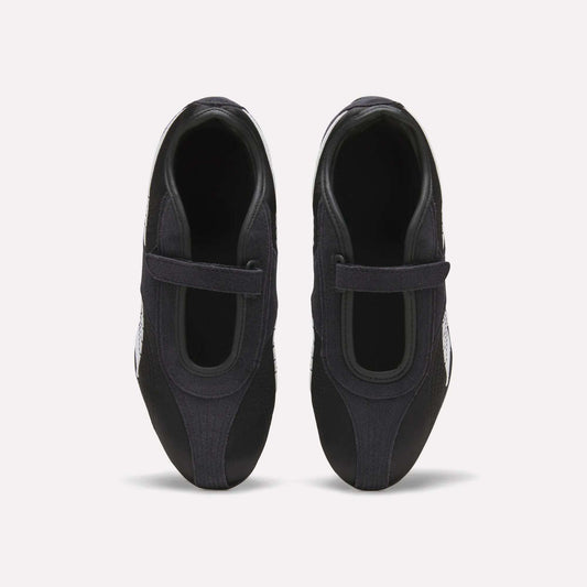 Top view of Reebok Women's Ultra Lo Mary Jane Shoes in black, featuring a single velcro strap on each, displayed side by side on a plain white background.