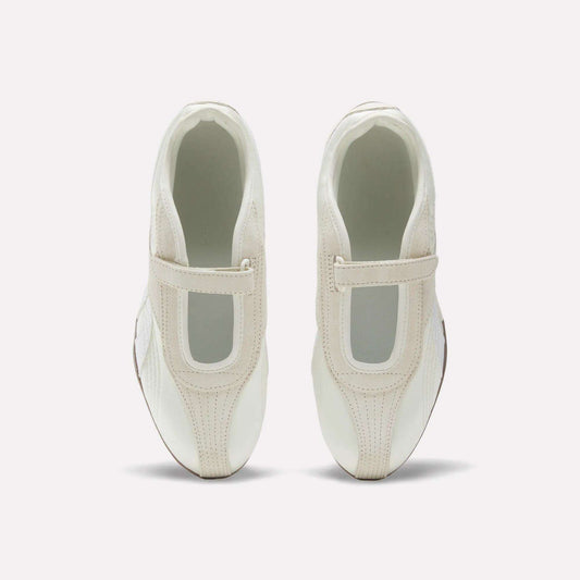 The Reebok Women's Ultra Lo Mary Jane Shoes are white slip-ons with beige accents and a wide elastic top strap, shown from above on a plain white background.
