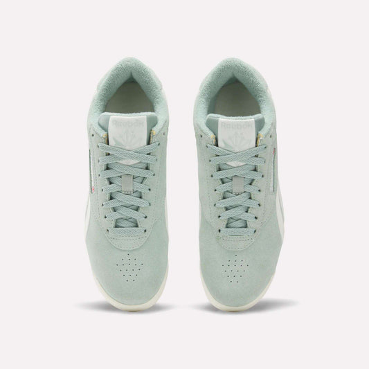 A pair of Women's Freestyle Lo Shoes by Reebok in light green suede are shown from above, displaying the tops, laces, tongues with Reebok logos, and placed side by side on a plain white background.