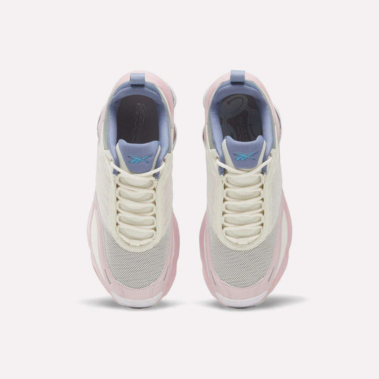 Top view of a pair of Reebok Women's DMX Series 3000 Training Shoes in white, cream, and light pink with mesh toes, lavender tongues, blue pull tabs, and white laces on a plain light background. These cushioned shoes are designed with DMX 3 Technology for superior comfort with every step.