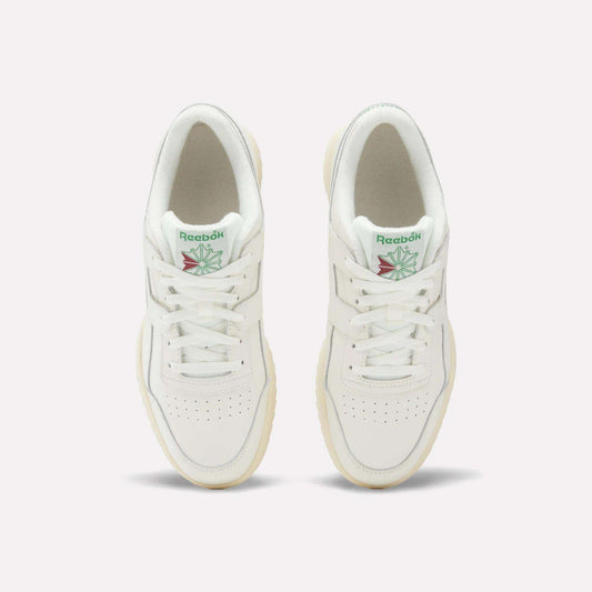 A pair of Reebok Workout Plus Ripple Shoes viewed from above, featuring green Reebok logos with a red and green design on the tongue, white laces, and cream-colored soles.