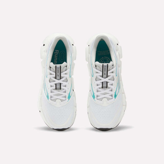 Top view of a pair of white Reebok Women's FloatZig 2 Running Shoes with turquoise accents and black soles on a plain white background. The insoles feature branding and design details, highlighting their springy cushioning.