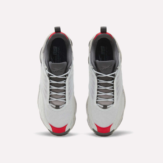 A pair of white Reebok Mita Sneakers x DMX Series 3000 athletic shoes with gray soles and laces, red accents on the toe and heel, and DMX moving air technology, seen from above on a white background.