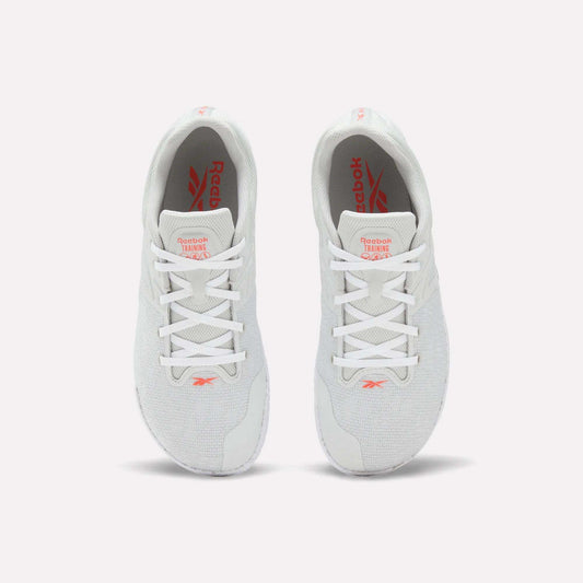 A pair of white Reebok Nano Zero Training Shoes, shown from above on a plain white background, feature red Reebok branding on the tongue and insole, white laces, a breathable mesh upper, and a zero-drop design.