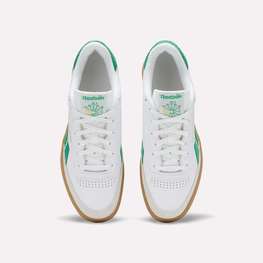 Top view of a pair of Reebok Men's Club C Revenge Vintage Shoes in white, featuring green accents, heritage branding on the tongue, and gum soles, placed side by side on a plain light background.