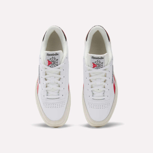 A pair of Men's Club C Revenge Shoes by Reebok in white leather, seen from above, featuring red and navy accents, perforated toes, and the classic Reebok logo with a starburst design on the tongue.
