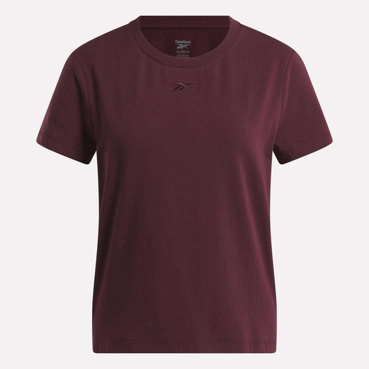 The Women's Graphic Glow Top by Reebok is shown on a white background, featuring a classic maroon design with a small embroidered logo on the chest.