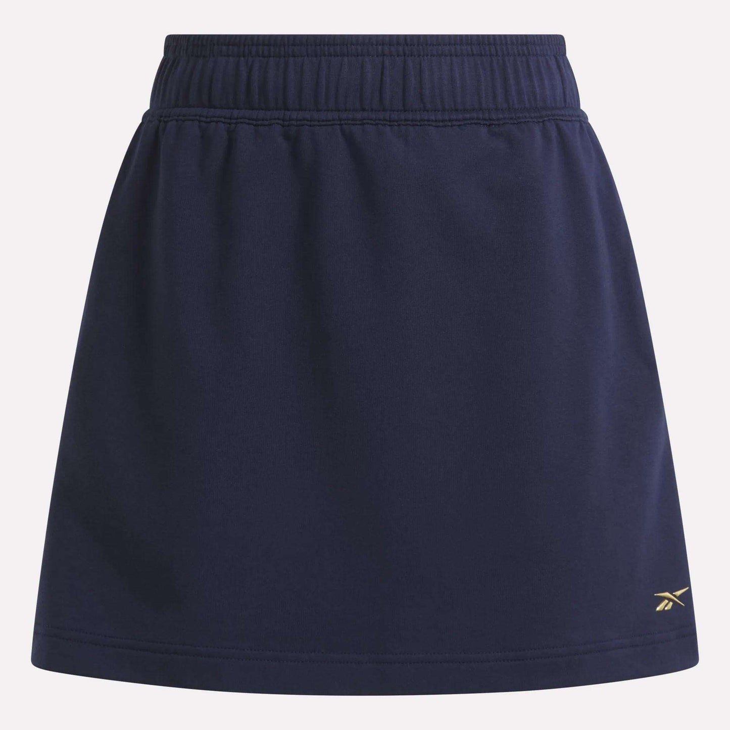 The Women's Logo Skirt by Reebok is a navy blue sports skirt with an elastic waistband, a small yellow logo near the right hem, and is made from a comfortable cotton blend.