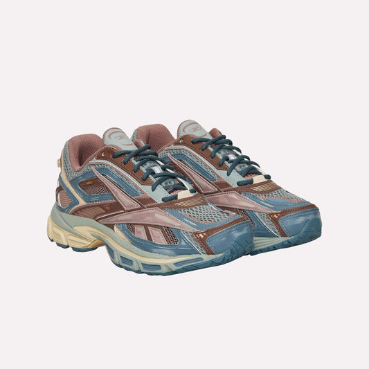 The Reebok Premier Road Ultra sneakers feature a multicolor design in blue, brown, and beige with mesh and synthetic panels, dual-density midsole for comfort, thick soles, and lace-up closures.