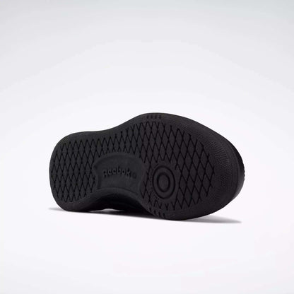 The image shows the black rubber sole of Reebok Kids' Club C Shoes - Little Kids, viewed from the bottom. The sole has a diamond tread pattern with the Reebok logo and branding in the center.