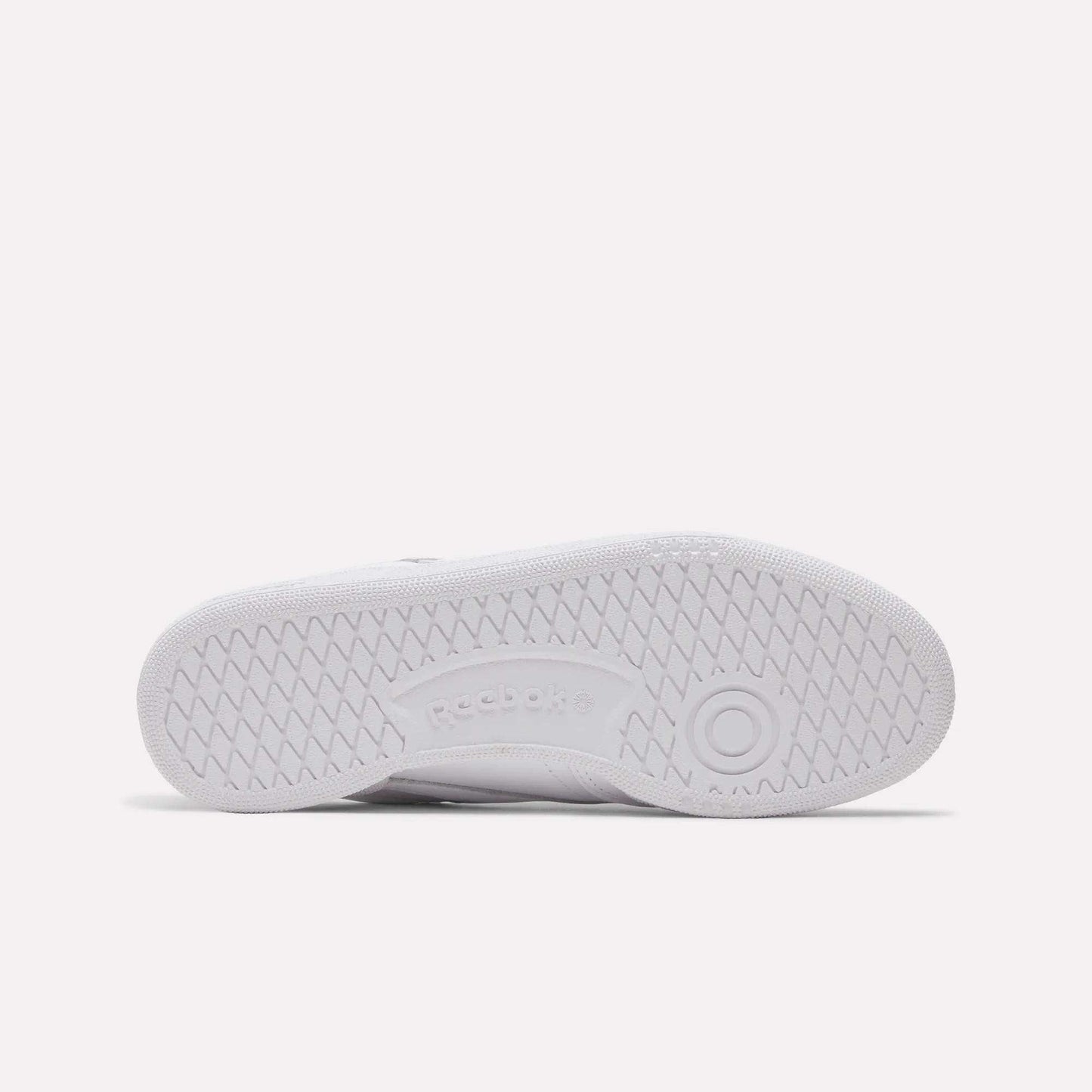 The image shows the sole of the Women's Club C 85 Shoes by Reebok, with a herringbone tread, a circular toe design, and an embossed Reebok logo—ideal for those seeking stylish women's footwear.
