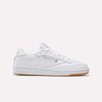 The Reebok Women's Club C 85 Shoes feature a white low-cut design, perforated toe, white laces, subtle branding, and a light brown rubber sole; shown on a plain white background.