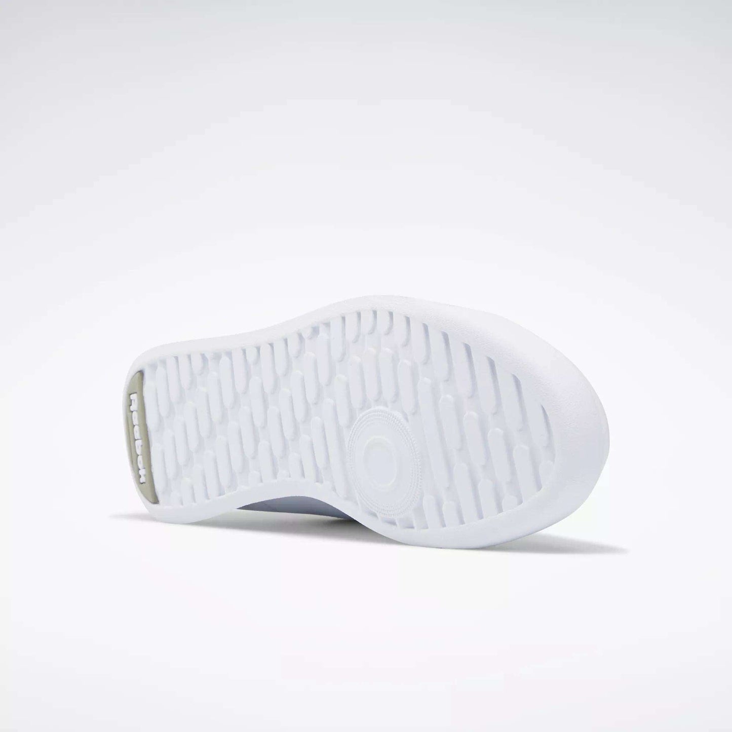The image shows the white rubber outsole of Reebok Women's Princess Shoes, featuring a textured grip pattern and the Reebok logo embossed near the heel against a plain, light background.