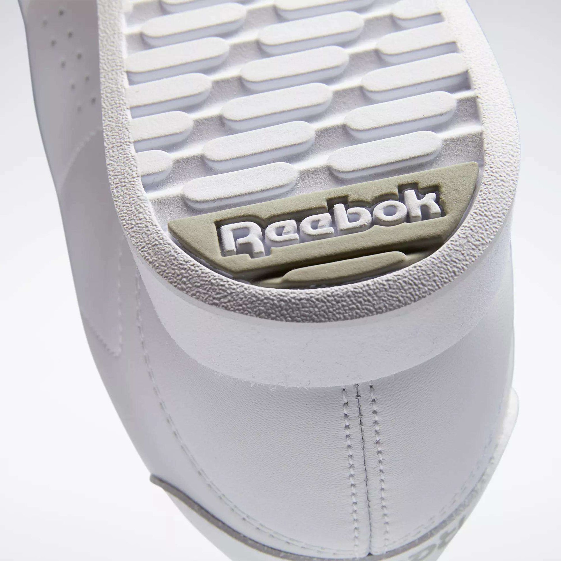 Close-up of the white sole on Reebok Women's Princess Shoes, highlighting the textured tread and gray-beige embossed Reebok logo near the heel—a classic heritage detail from this iconic brand.
