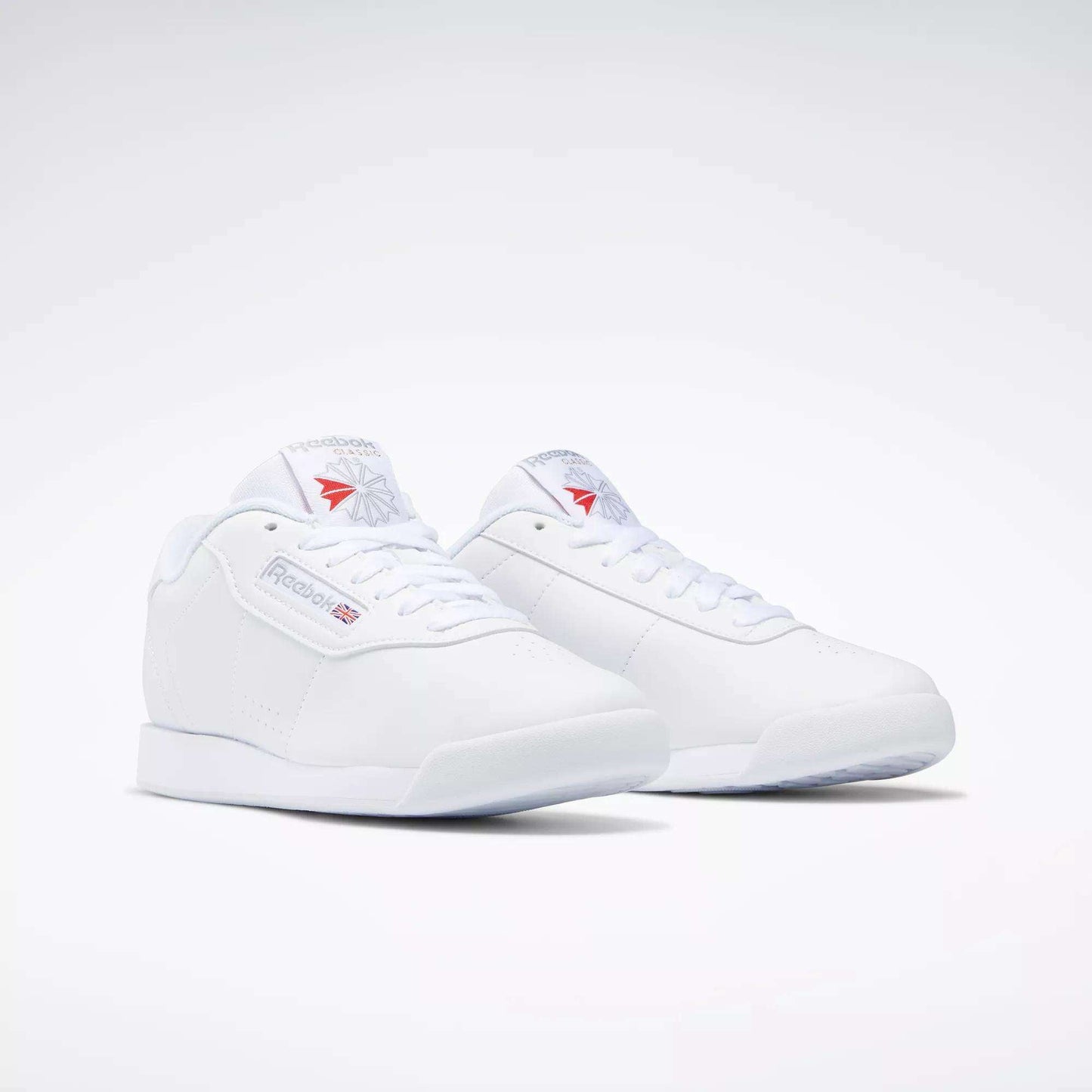 The Reebok Women's Princess Shoes feature a classic low-top design with lace-up fronts and subtle Reebok branding on the sides, tongue, and heel, highlighting heritage style against a plain white background.