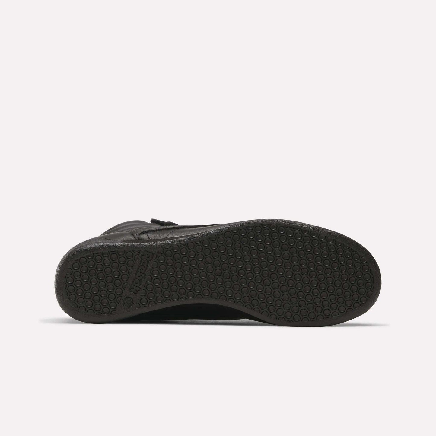The Reebok Women's Freestyle Hi Shoes in black feature a textured rubber outsole with a hexagonal pattern and visible branding near the heel—ideal for women's fitness or as a stylish high-top option.