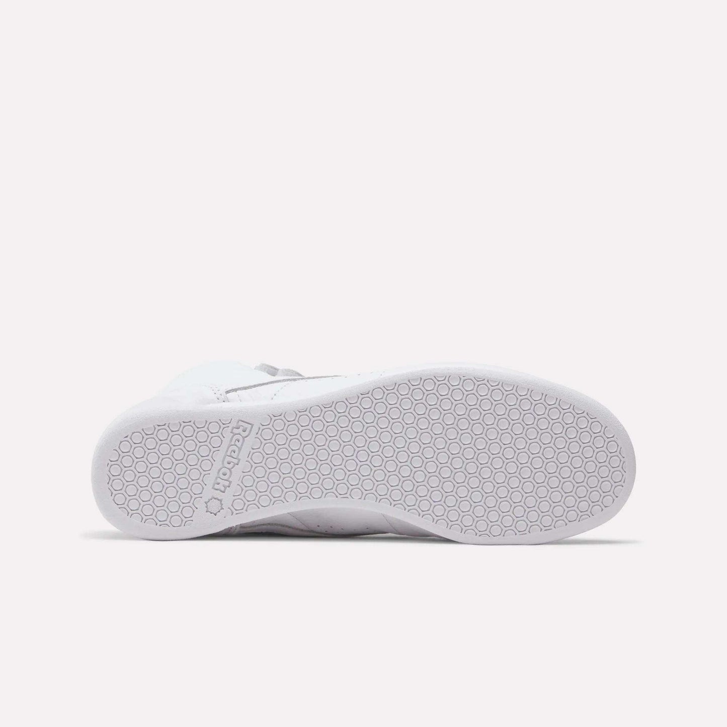 The Reebok Women's Freestyle Hi Shoes feature a white textured rubber sole with a hexagonal pattern, embossed Reebok logo near the heel, and are perfect for fitness enthusiasts who love stylish high tops.