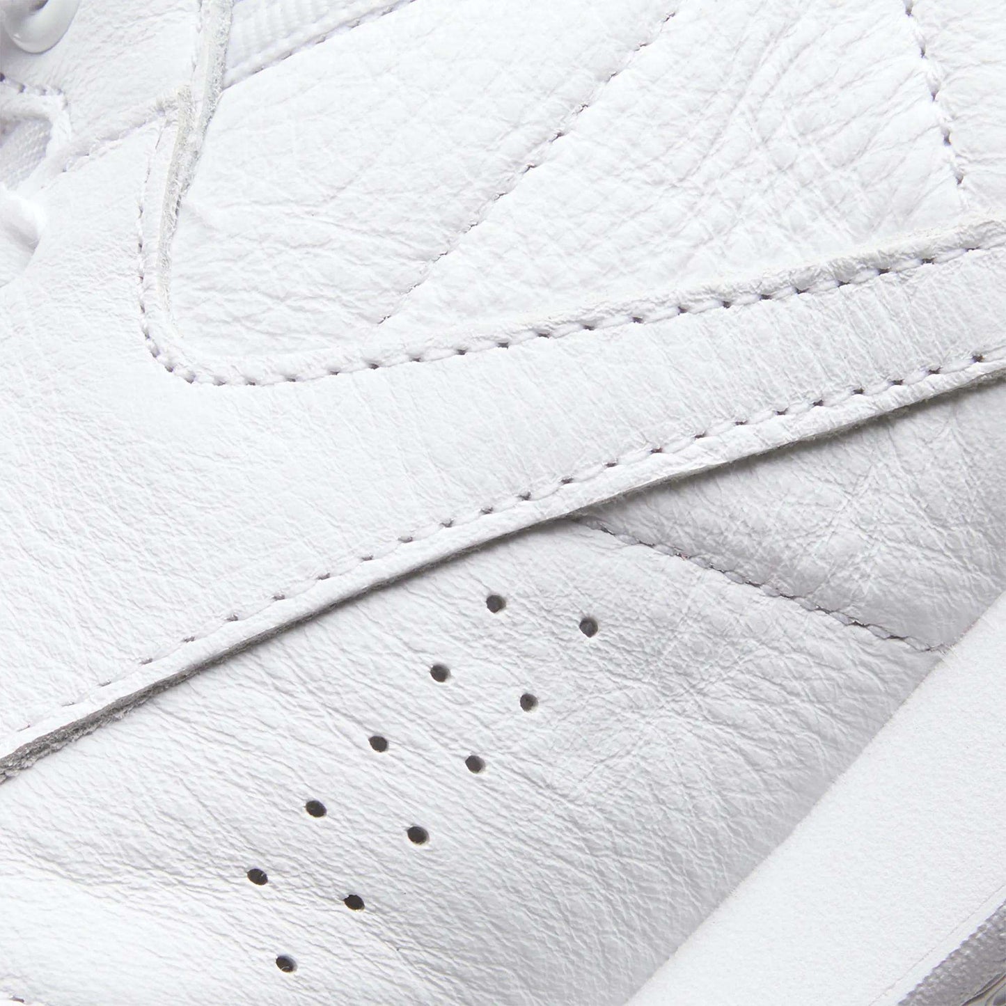 Close-up of the Reebok Women's Freestyle Hi Shoes in white leather, featuring textured material, detailed stitching, and three small ventilation holes—ideal for women's fitness or high top sneaker fans.