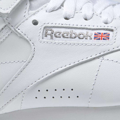 Close-up of the Women's Freestyle Hi Shoes by Reebok, showcasing the stitched logo, Union Jack flag, and crisp white laces—ideal for women who value both style and comfort in their fitness footwear.