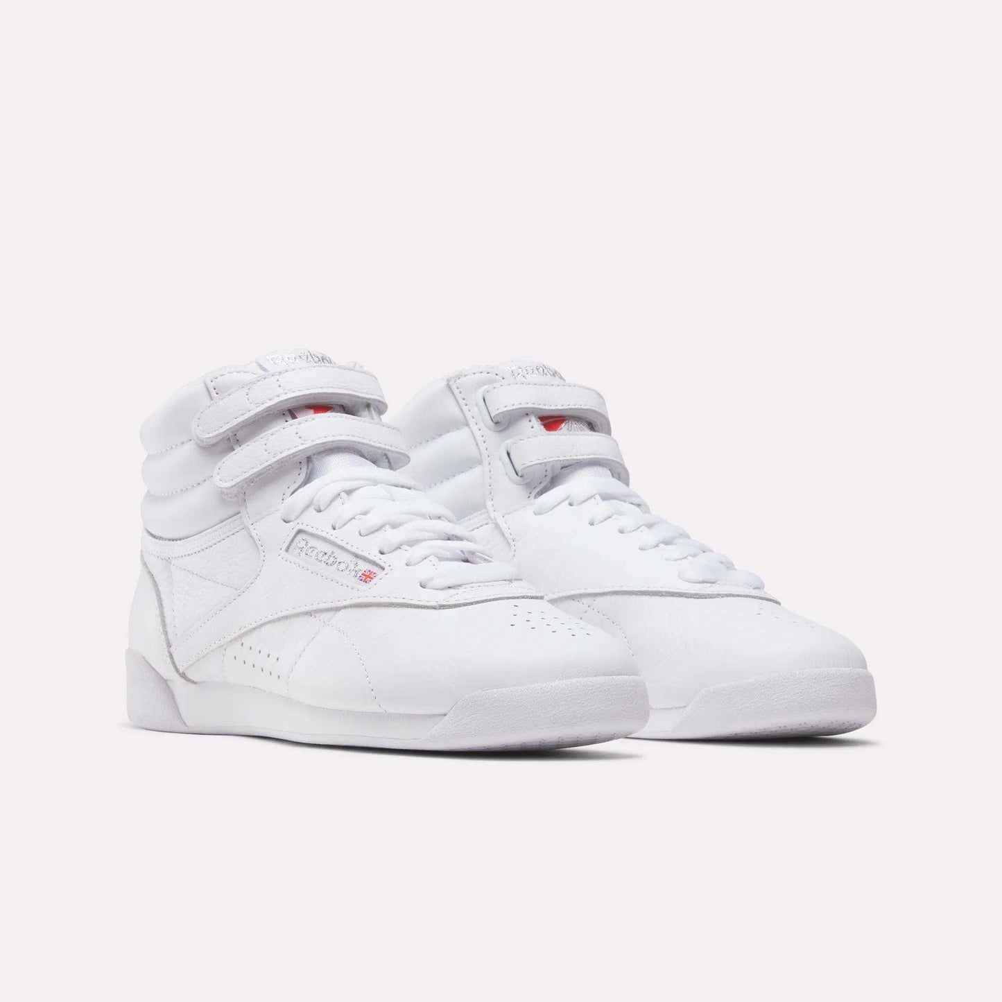 Reebok Women's Freestyle Hi Shoes in white feature high-tops, velcro straps, and laces—ideal for fitness—shown on a plain white background.