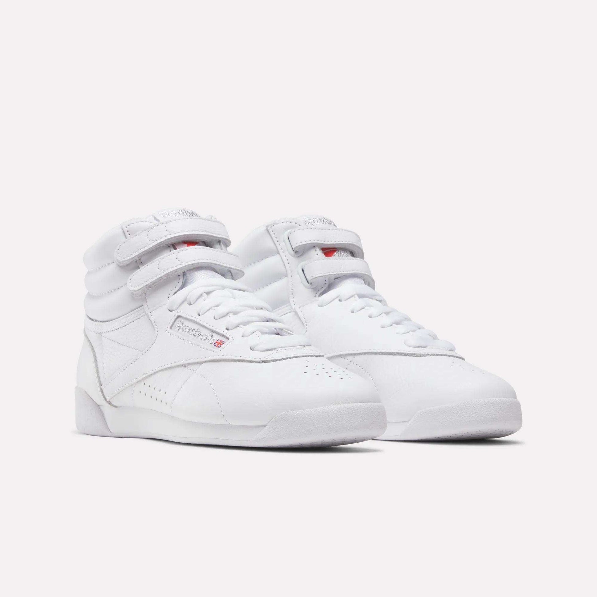 Reebok Women's Freestyle Hi Shoes in white feature high-tops, velcro straps, and laces—ideal for fitness—shown on a plain white background.