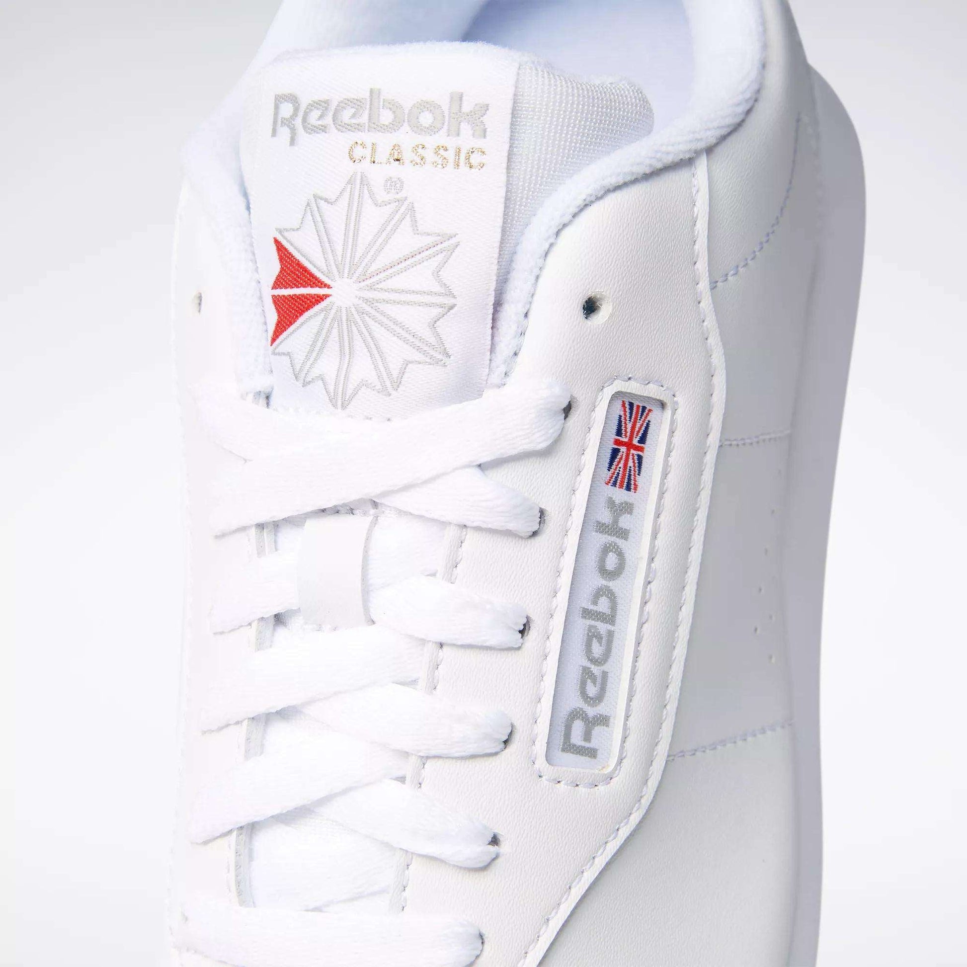Close-up of a classic women's shoe: the Reebok Women's Princess Wide Shoe in white, featuring signature branding and heritage cushion comfort with neatly tied white laces.