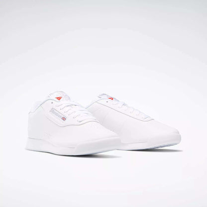 The Women's Princess Wide Shoes by Reebok feature a classic, minimalistic design with the iconic Union Jack logo and branding on the side, showcased against a plain white background.