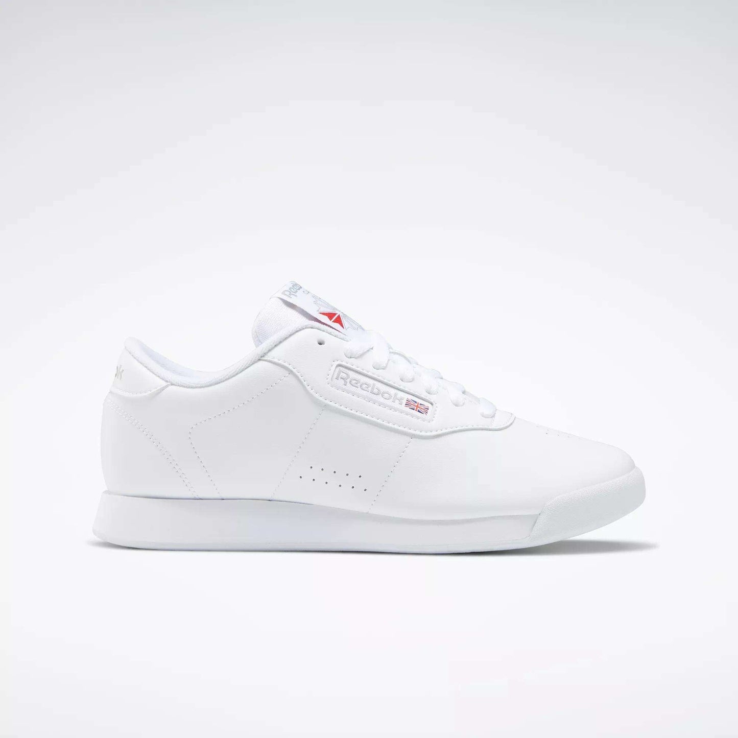 The Reebok Women's Princess Wide Shoes are classic white low-top sneakers for women, featuring subtle Reebok branding and the Union Jack logo on the side and tongue, shown against a plain light background.