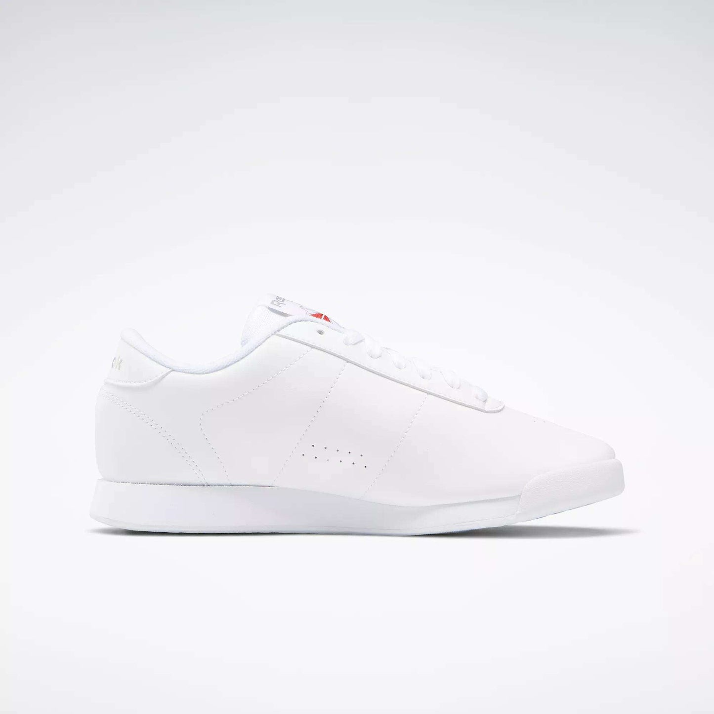 The Reebok Women's Princess Wide Shoes are white low-top sneakers with a minimalist design, flat sole, subtle side perforations, white laces, and a discreet Union Jack logo—highlighting classic women's shoe heritage—shown on a plain white background.