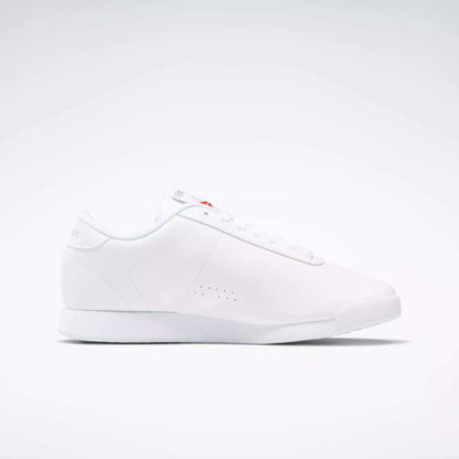 The Reebok Women's Princess Wide Shoes are white low-top sneakers with a minimalist design, flat sole, subtle side perforations, white laces, and a discreet Union Jack logo—highlighting classic women's shoe heritage—shown on a plain white background.
