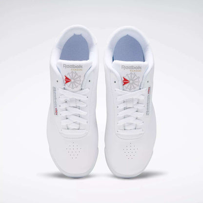 A pair of classic Reebok Women's Princess Wide Shoes with white laces, viewed from above. These sneakers display the Union Jack logo in red and gray on the tongue and side, set against a plain white background.