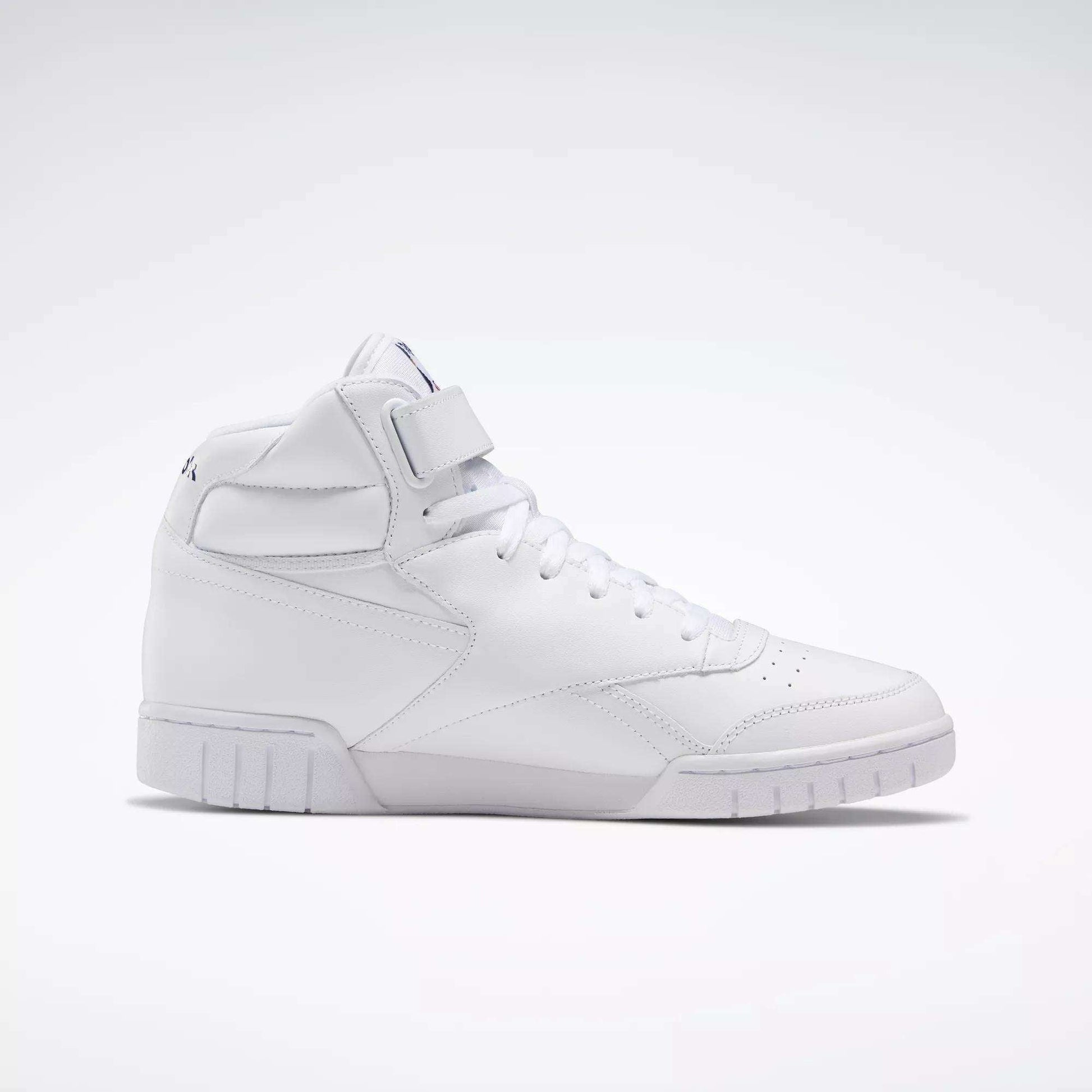 The Reebok Men's EX-O-FIT Hi Shoes are white high-top sneakers with a lace-up front, velcro strap, and subtle stitching shown in side profile against a plain light background, featuring an old-school design.