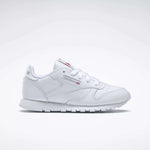 The Reebok Kids' Classic Leather Shoes - Preschool feature a white leather upper, white laces, low-top design, and subtle Reebok branding on the side and tongue, shown against a plain light background.